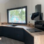 Réalisations Cusines DEBARD - Cuisine asymétrique, hotte décorative meubles gris foncé et plan de travail bois clair
